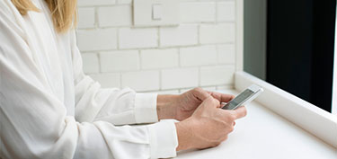 photo of woman banking on phone - links to business mobile banking page