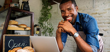 photo of business owner using laptop - links to business online banking page