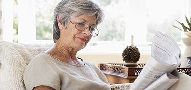 photo of woman reading newspaper - links to retirement page